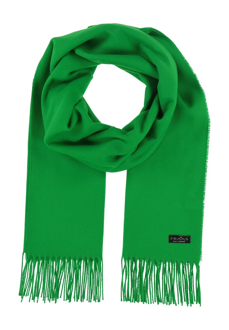 Écharpe verte en tissu doux et léger, ornée d'un pompon aux extrémités et d'une étiquette noire avec du texte blanc.