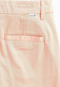 Levi's pastellpeachfärgade byxor med en mjuk twillstruktur, med en bakficka och en vit logotagg på midjebandet.