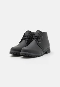 Botas de tobillo de cuero negro con textura suave, punta redonda, cierre de cordones en la parte frontal, tacón bajo y suela de goma con relieve. Logotipo grabado en el lateral.