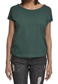 Zeleno-černý pruhovaný top s krátkým rukávem a kulatým výstřihem, doplněný o roztrhané tmavé džíny s dírami a třepenými okraji.