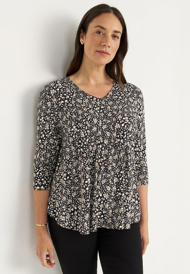 Zwarte top met 3/4 mouwen, v-hals, met een bloemenpatroon in wit en beige. De stof is zacht met een losse, vloeiende silhouette.