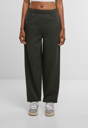 Grå, bredbenede sweatpants med elastisk talje, lavet af blødt materiale, parret med grå og hvide sneakers.