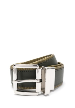 Ceinture en cuir vert foncé roulée avec un bord en tissu beige et une boucle rectangulaire en métal argenté brillant sur fond blanc.
