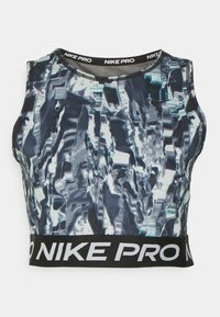 Il crop top Nike Pro presenta un motivo astratto riflettente in blu e argento, con una cintura elastica nera che mostra "NIKE PRO" in bianco.