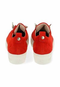 Baskets en velours rouge avec semelles blanches, dotées d'un onglet à l'arrière, de matériel en métal et d'une doublure intérieure lisse.