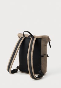 Sac à dos à rabat marron avec dos en maille noire, bretelles rembourrées et poche latérale. Matériau durable, design simple et forme fonctionnelle.