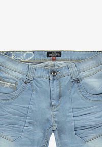 Lichtblauwe spijkerbroek met knoopsluiting, voorzien van vijf zakken, gestikte details en lichte vervaging over de stoftextuur.