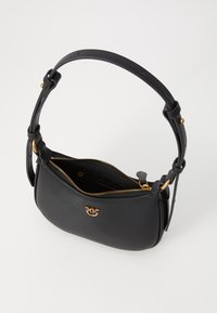 Melnas ādas rokassomas ar izliekta formu, zelta rāvējslēdzis un logo detaļa. Iekļautā noņemamā, mezglota siksna nodrošina daudzveidīgu nēsāšanu.