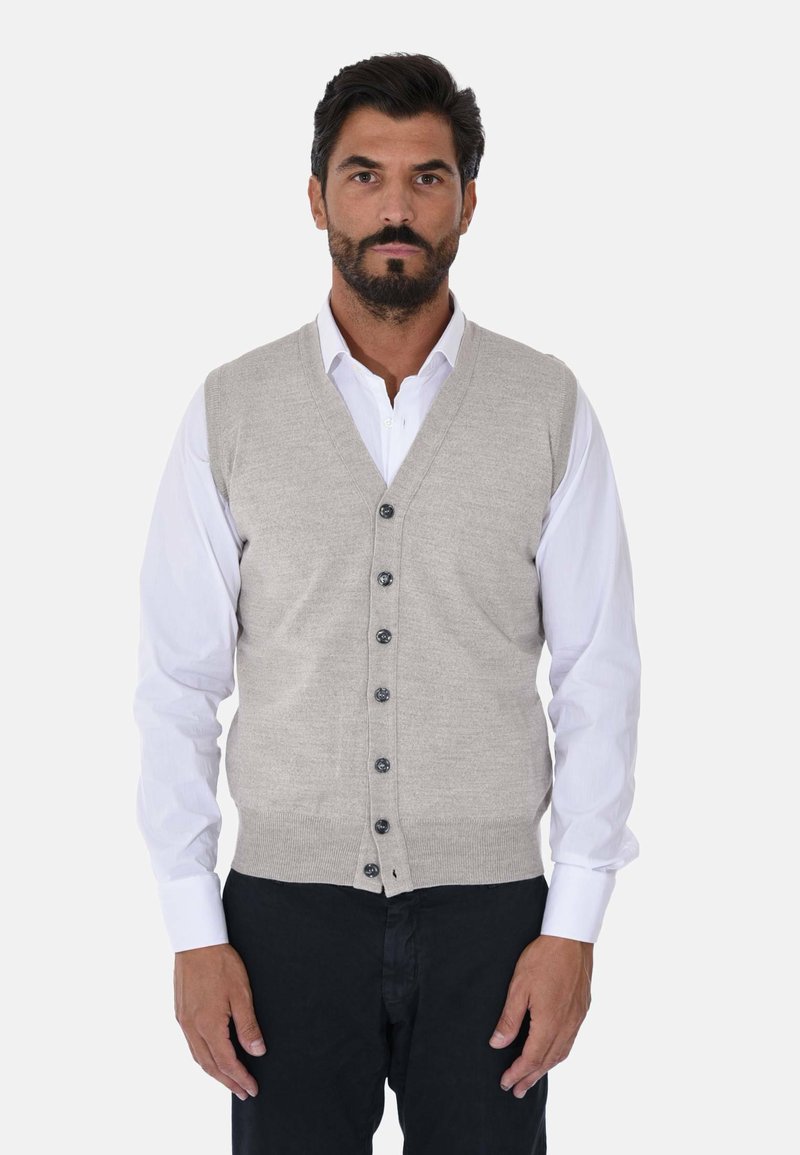 Gilet grigio lavorato a maglia con scollo a V, caratterizzato da una chiusura con bottoni e orlo a coste, indossato sopra una camicia bianca, abbinato a pantaloni scuri.