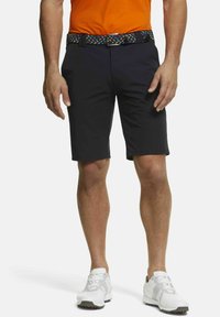 Marineblauwe shorts met een rechte snit en een gladde textuur, gecombineerd met een kleurrijke geweven riem. Witte sportschoenen maken de outfit compleet.