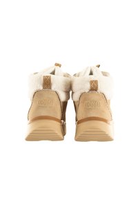 Par de botas de ante color marrón claro con forro de felpa blanca, suelas de goma y lengüetas, vistas desde atrás sobre un fondo blanco.