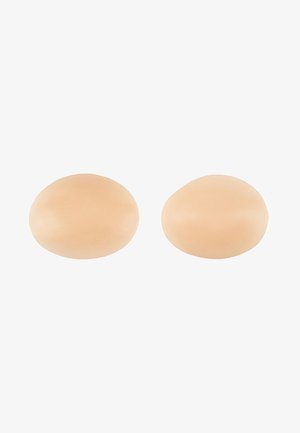 Deux coussinets en silicone ovales, lisses, de couleur chair, avec une texture douce, conçus pour une intégration sans couture et un confort optimal.