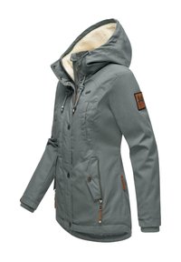 Szürke külső dzseki, műszőrme béléssel ellátott kapucnival, cipzárral és gombokkal záródó elülső résszel, több zsebbel és bőr- és textilbetétekkel.