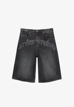 Zwarte denim shorts met brede pijpen, voorzien van voorzakken, tailleband met lussen en knoopsluiting, getoond op een witte achtergrond.