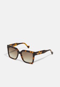Ochelari de soare tortoise cu o ramă pătrată, lentile degradé și un branding subtil pe bradă. Suprafață texturată cu margini rotunjite.