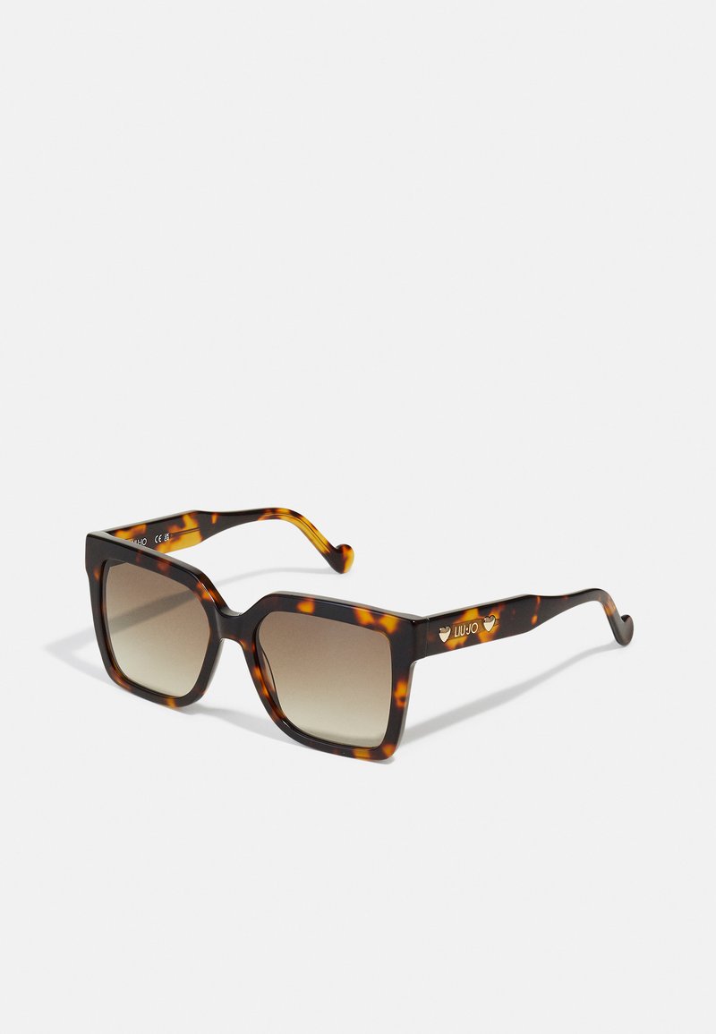 Ochelari de soare tortoise cu o ramă pătrată, lentile degradé și un branding subtil pe bradă. Suprafață texturată cu margini rotunjite.