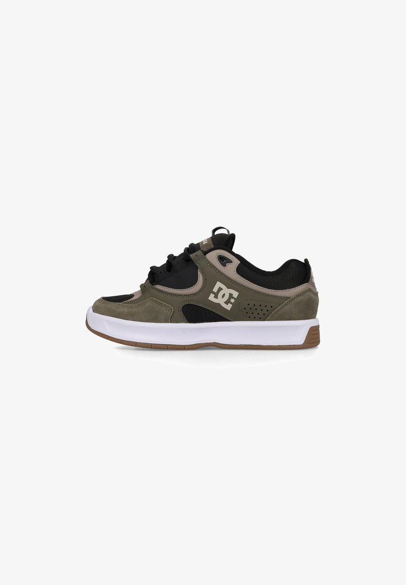 Black and olive green sneakers with a suede and mesh design, white soles, and prominent logo detailing on the side.