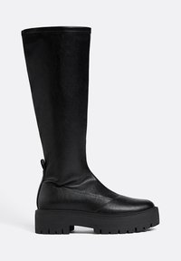 Černé kozačky do výšky kolen s hladkým koženým povrchem, silnou gumovou podrážkou a kulatou špičkou. Obsahuje poutko na zadní straně pro snadné obutí.