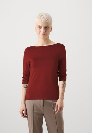 Haut bordeaux à manches longues avec un col bateau large, fabriqué dans un tissu lisse, associé à un pantalon beige clair. Présente des manches ajustées.