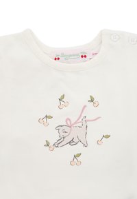 Biała bawełniana koszula z ilustracją szarego psa z różową wstążką, otoczona jasnoróżowymi wiśniami i zielonymi liśćmi. Dwa zapięcia na guziki.