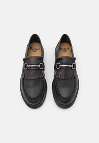 Mocassins en cuir noir avec une finition texturée, dotés d'une boucle et d'un détail frangé sur le dessus. Semelle intérieure rembourrée et design à bout arrondi.