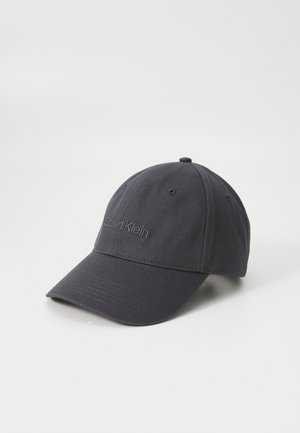 Black baseball cap made of cotton. Features a curved brim, embroidered "Calvin Klein" logo on the front, and six ventilation eyelets.