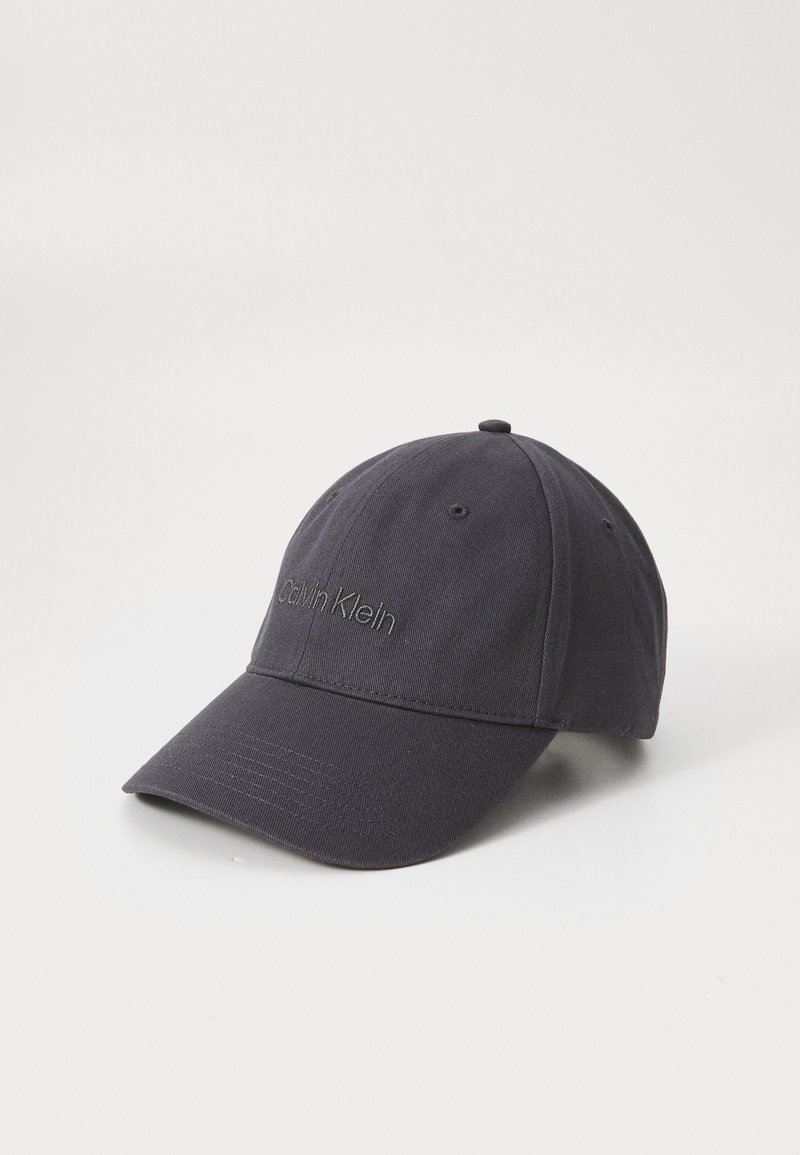 Boné de baseball preto feito de algodão. Apresenta uma aba curva, o logótipo "Calvin Klein" bordado na frente e seis ilhoses de ventilação.