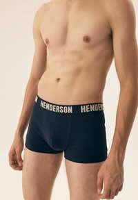 Granatowe bokserki w kolorze niebieskim z beżowym elastycznym pasem z logo "HENDERSON", wykonane z miękkiego, elastycznego materiału, zapewniające dopasowany krój i gładką teksturę.