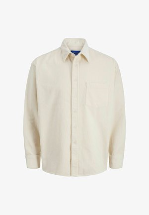 Beige ribfluwelen overhemd met een knoopsluiting aan de voorkant, kraag, lange mouwen en een enkele borstzak. Het overhemd heeft smalle verticale strepen.