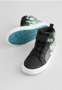 Schwarze High-Top-Sneaker mit grünem und blauem R2-D2-Graphic, weißer Sohle und schwarzen Schnürsenkeln. Mit strukturierten Akzenten und Velcro-Riemen.