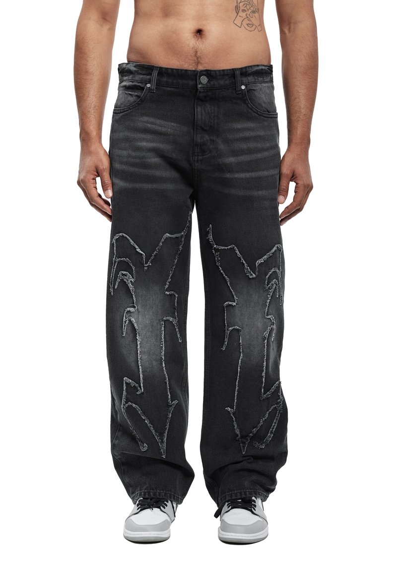 Μαύρο τζιν με άνετη εφαρμογή, με φθαρμένες λεπτομέρειες και ραφές σε στυλ γκράφιτι στο μπροστινό μέρος. Ολοκληρωμένο με κλασικές τσέπες.
