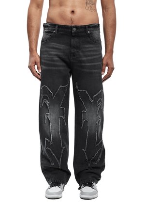 Pantalones vaqueros negros de mezclilla con un ajuste relajado, con detalles desgastados y costuras estilo graffiti en la parte delantera. Terminados con bolsillos clásicos.