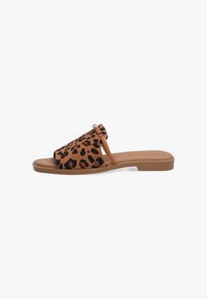 Leopardprint slide-sandaal heeft een bovenwerk van bruin suede met uitsnijdingen, een enkele band en een platte rubberen zool. Accenten met metalen details.