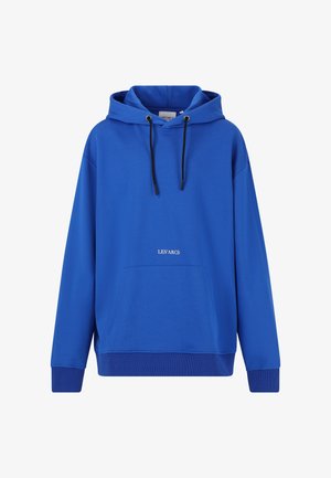 Blå hættetrøje med en frontlomme og sorte snore, parret med sorte slim-fit bukser og sorte sneakers, med et logo på begge beklædningsgenstande.