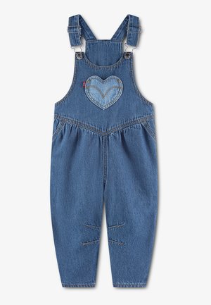Salopette en jean bleu pour enfants avec bretelles réglables et écusson en forme de cœur sur la poche poitrine.