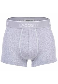 Grå bomullsboxer med en kontrasterande grå midja som har "Lacoste"-logotypen. Har en slät yta och söm-detaljer.