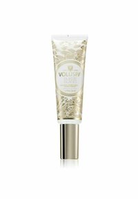 Voluspa Suede Blanc håndcreme i en dekorativ gylden og hvid tube. Har en pumpe-dispenser og et elegant blomstermønster. Kapacitet på 50 ml.