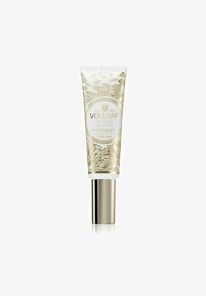Voluspa Suede Blanc käsivoide koristeellisessa kultaisessa ja valkoisessa tuubissa. Varustettu pumppuuduttajalla ja elegantilla kukkakuviolla. 50 ml:n kapasiteetti.