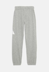 Pantalones de chándal grises hechos de una tela suave, con una cintura elástica y un acento triangular blanco cerca del muslo izquierdo. Diseño de pierna ajustada.