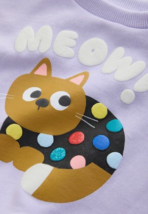 Lavandas krāsas sporta krekls ar karikatūras kaķi, kura melnais apļveida ķermenis ir rotāts ar krāsainiem plankumiem un ar baltu uzrakstu "MEOW!".