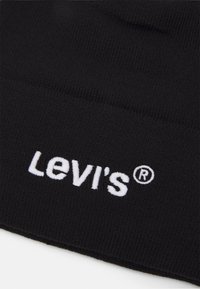 Czarna dzianinowa czapka z prążkowanym wzorem, z białym haftowanym logo "Levi's" oraz symbolem znaku towarowego.