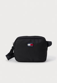 Fekete nylon keresztpántos táska, téglalap alakú, cipzáras záródással, állítható pánttal, valamint egy színes Tommy Jeans logoval az elején.