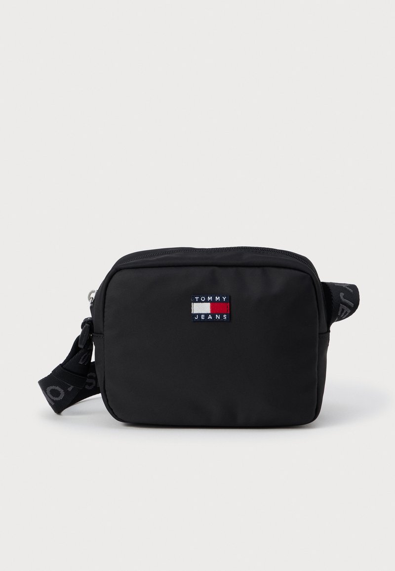 Fekete nylon keresztpántos táska, téglalap alakú, cipzáras záródással, állítható pánttal, valamint egy színes Tommy Jeans logoval az elején.