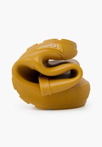 Chaussure en caoutchouc jaune, pliée, avec une semelle texturée pour une meilleure adhérence et une sangle avec une marque en relief près de la zone des orteils. Surfaces lisses dans l'ensemble.