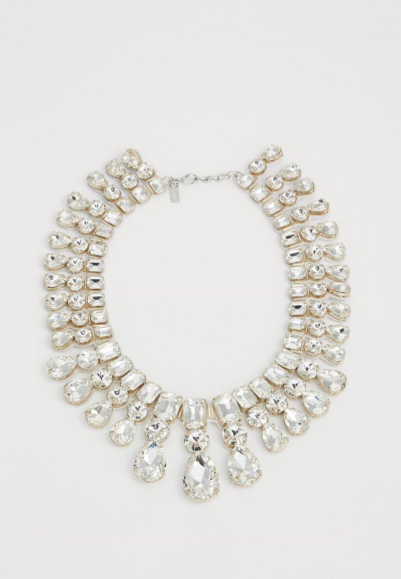 Náhrdelník s několika velkými jasnými drahokamy ve tvarech slzy, kruhu a obdélníku uspořádanými v vrstevnatých řadách se stříbrným zapínáním.