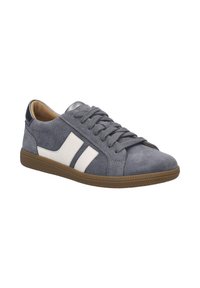 Sneaker in suede grigio con strisce bianche laterali, punta rotonda, chiusura con lacci e suola in gomma marrone. Accento metallico sul tallone.