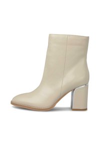 Bottines beiges à bout pointu, texture en cuir lisse et talon épais orné d'argent. Design minimaliste et finition sans couture.