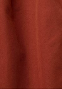 Roestkleurige stof met een diagonale ribbelstructuur, voorzien van een gladde afwerking en subtiele glans. Geschikt voor verschillende textieltoepassingen.