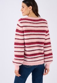 Maglione a righe in rosa, bianco e bordeaux. Presenta una vestibilità morbida, polsini a coste e una finitura morbida e testurizzata.