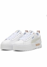 White sneakers with a chunky platform sole, smooth synthetic material, subtle beige accents, and a light blue logo on the tongue.